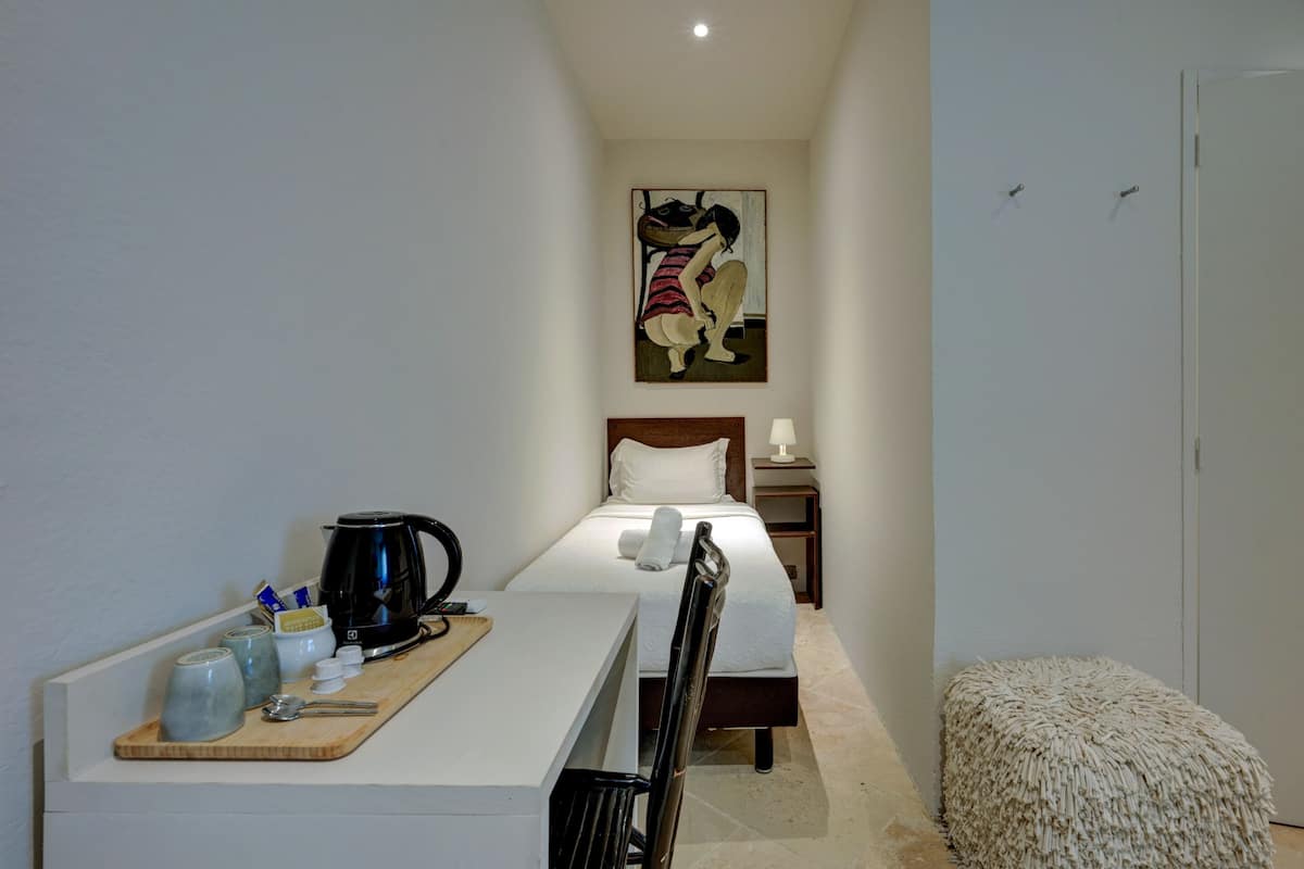 Habitació d'hotel amb un llit, una taula de nit i un quadre penjat a la paret.