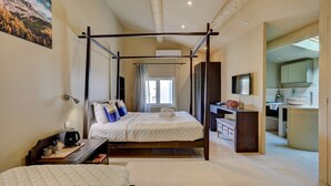 Une chambre à coucher avec un lit à baldaquin, un bureau avec un ordinateur et une vue sur la salle de bain.