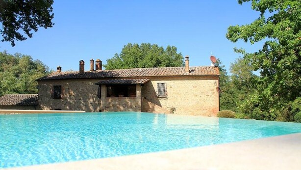 A swimming pool with a stone building in the background.
