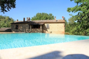 Una piscina con un edificio de piedra al fondo.