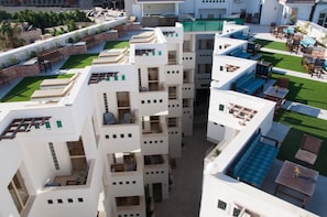Un hôtel à plusieurs étages doté d’espaces de détente en plein air, de balcons et d’une piscine.