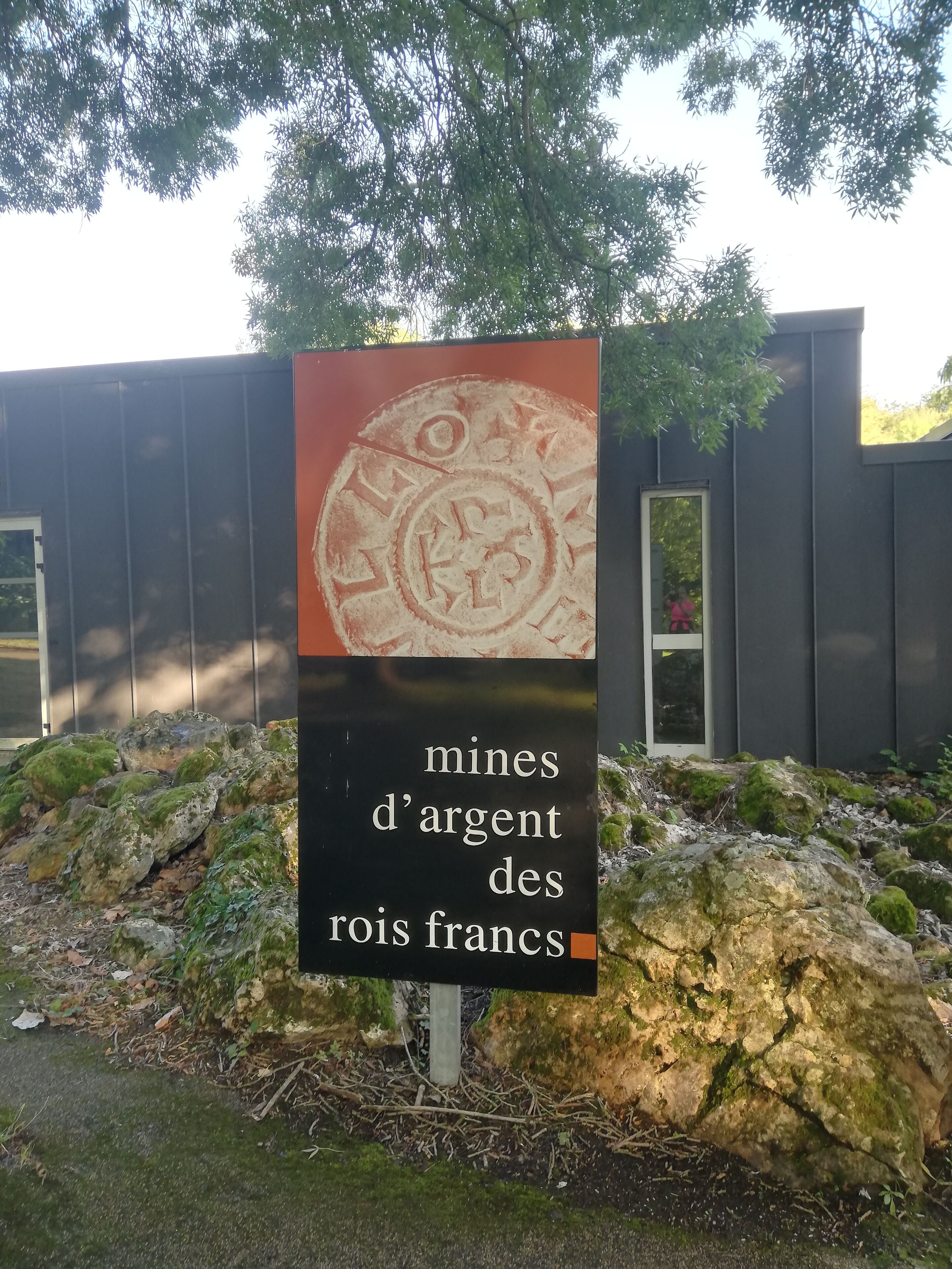 Een bord met de tekst 'mines d'argent des rois francs' en een cirkelvormig embleem.