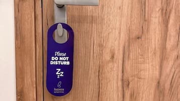 A wooden door with a keyhole and a purple tag hanging on it.