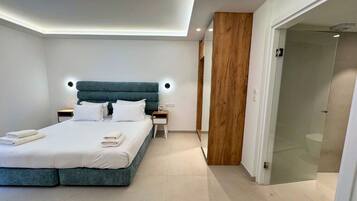 A modern bedroom with a large bed, bedside tables, and a wooden accent wall.