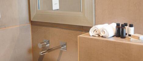 A bathroom with a white sink, a mirror, and toiletries on the counter.