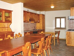 Une cuisine en bois avec une table et des chaises, des placards en bois et une fenêtre.