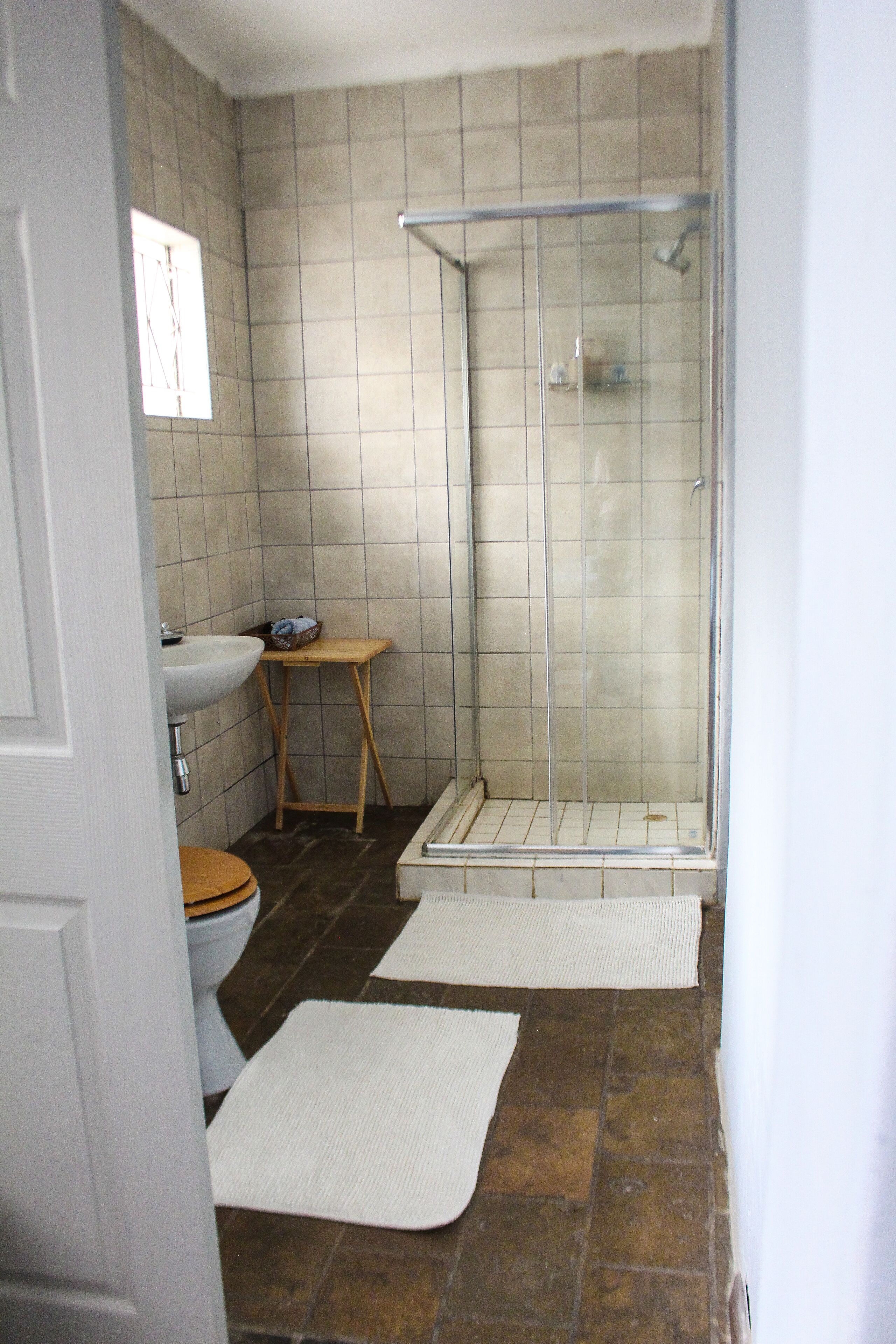 A bathroom with a shower, sink, and toilet.