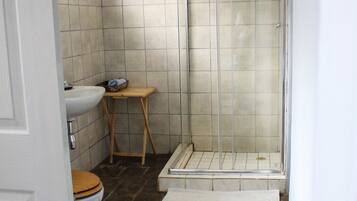 A bathroom with a shower, sink, and toilet.