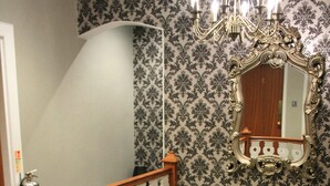 A staircase with ornate white railings and a chandelier above. - North Kessock Hotel (Inverness)