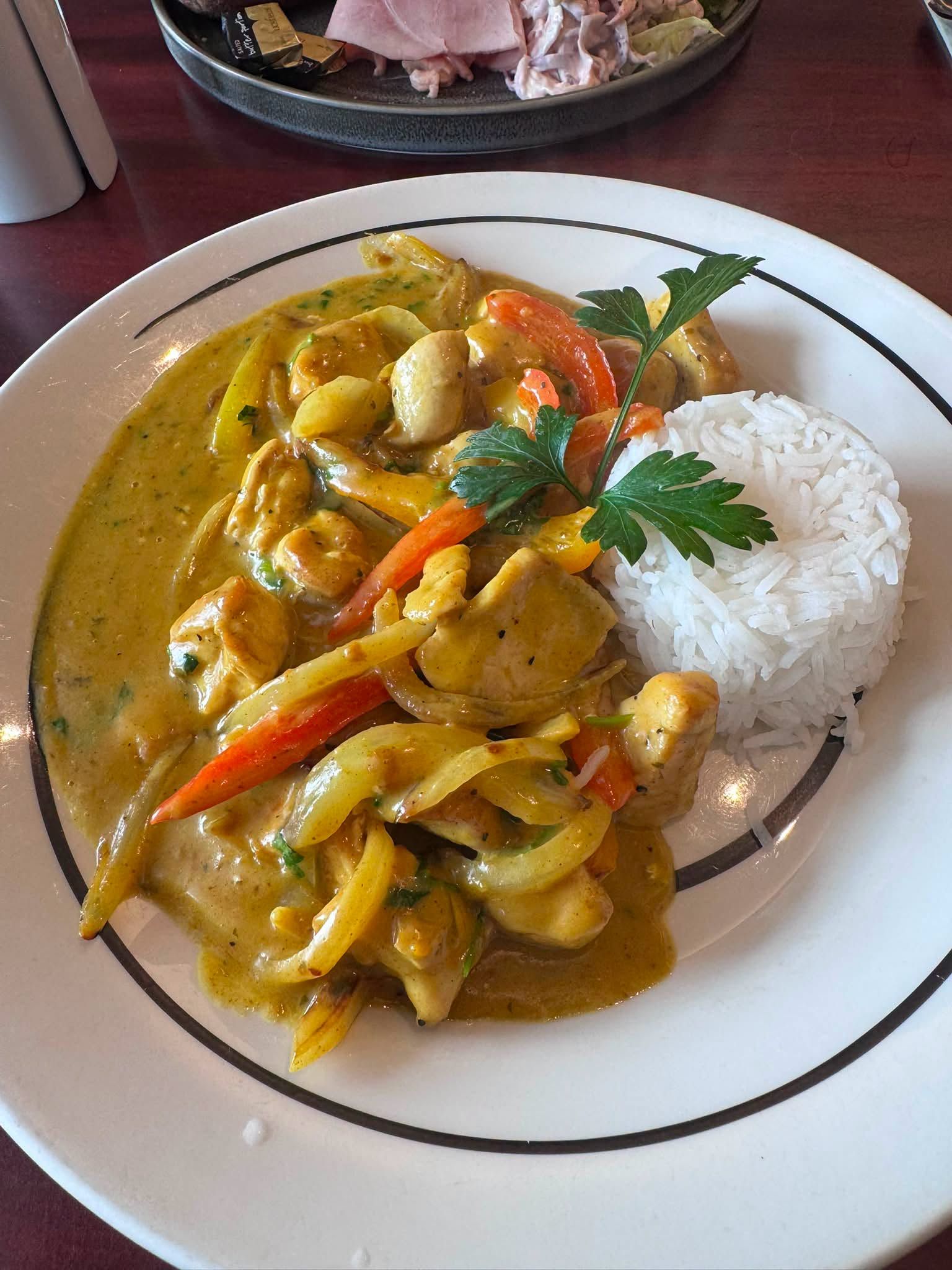 Un plato de curry con verduras y arroz.