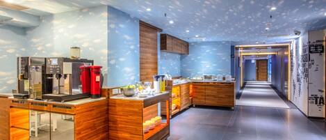A modern kitchen area with built-in appliances, wooden cabinets, and a long counter.