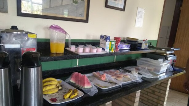 Una cocina con cafetera, licuadora y diversos alimentos sobre la encimera.