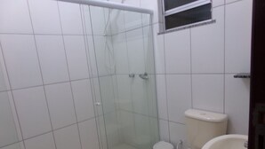 Un baño con cabina de ducha de vidrio, inodoro y bidé.
