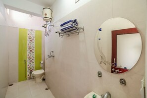 Un baño con inodoro, ducha, lavabo, espejo y toallero.