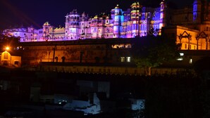 A historic building with multiple domes and towers, illuminated at night. - Janak Niwas (Udaipur)