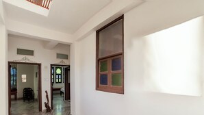 A hallway with a marble floor, a wooden bench, and a decorative sculpture. - Janak Niwas (Udaipur)
