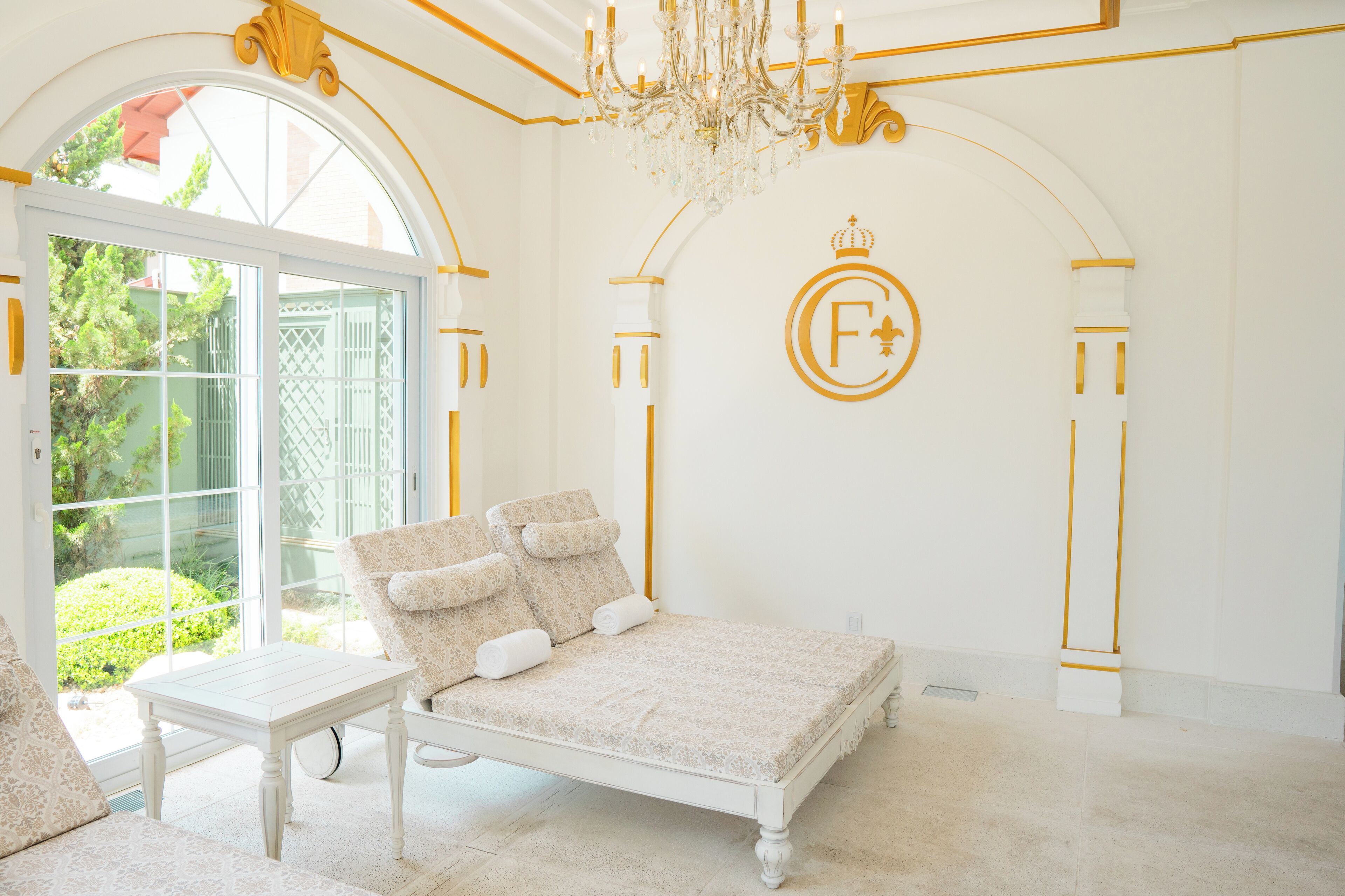 Quarto com cama, mesa e lustre.