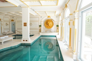 Una piscina techada, sillones reclinables de piscina