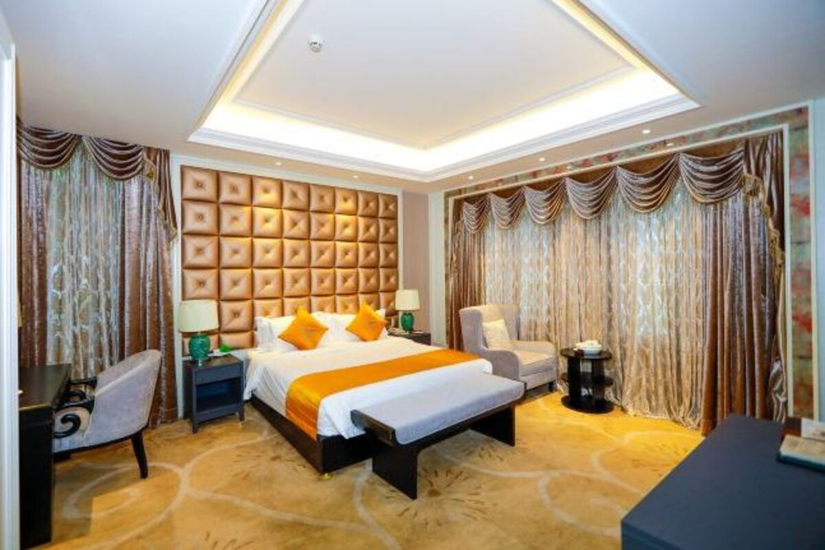 Une chambre d’hôtel avec un grand lit, un bureau, une chaise et une petite table.