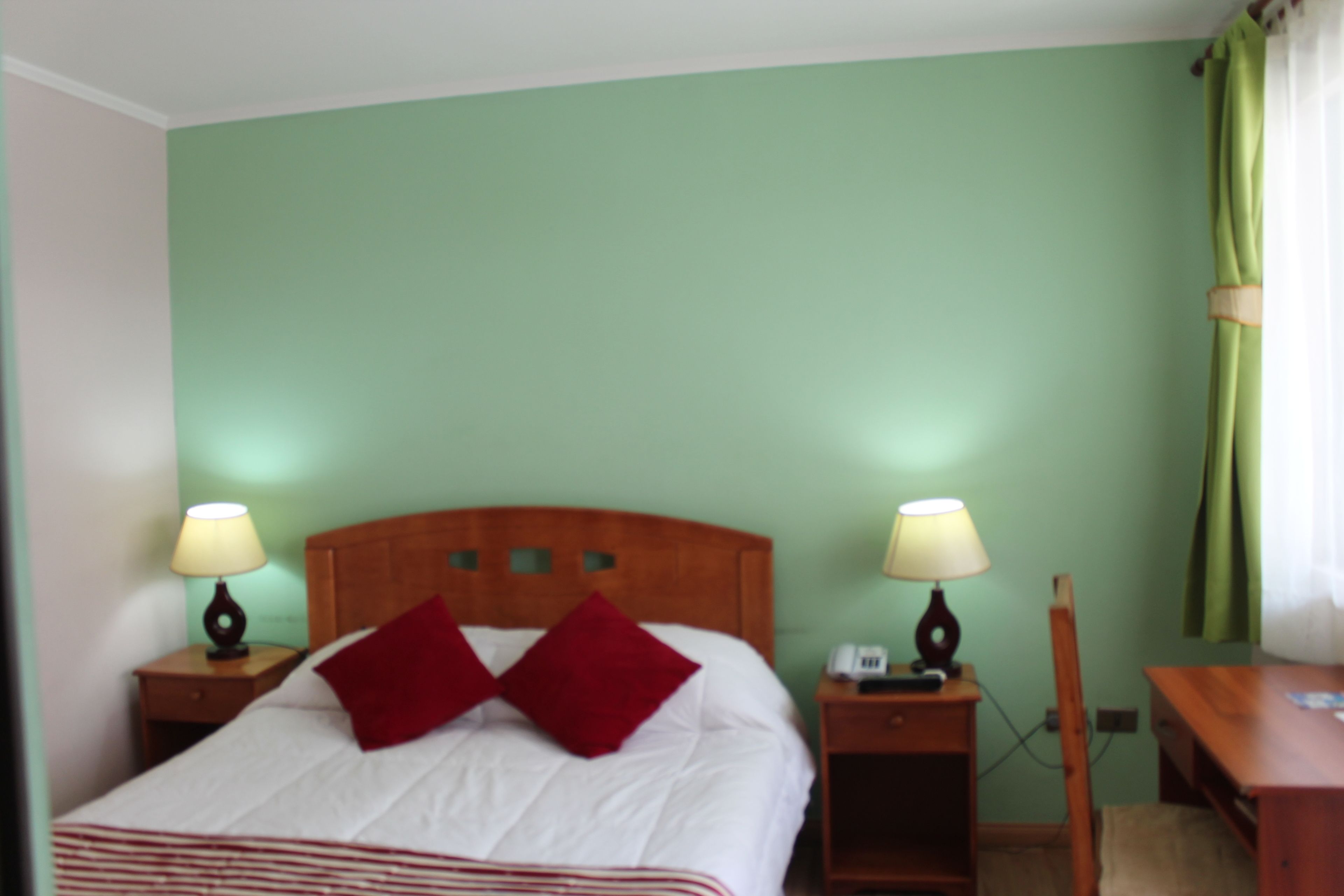 Een kamer met een bed, twee nachtkastjes en een bedbank.