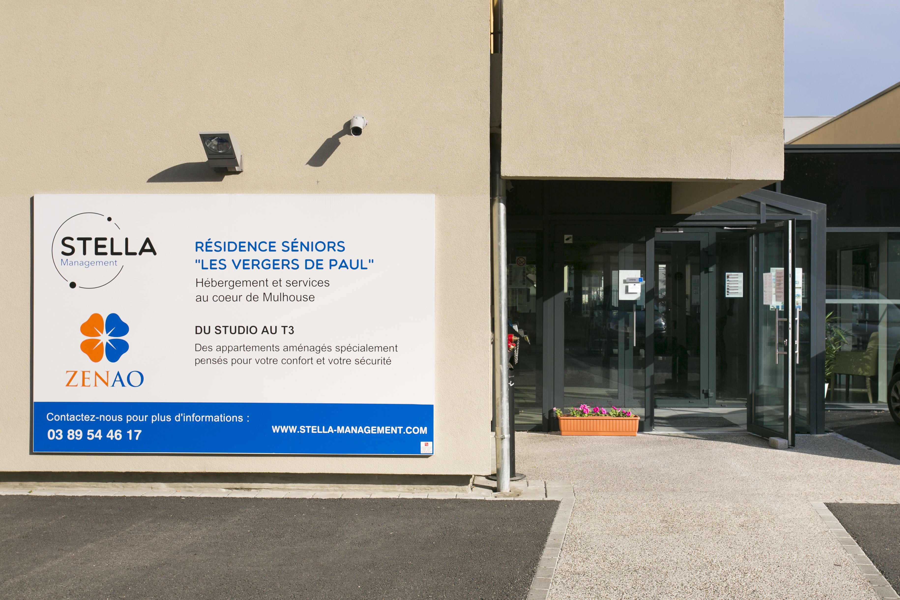 Een bordje voor STELLA Management en ZENAO, met advertenties voor seniorenwoningen en appartementen bij studio T3.