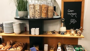 Un bufé de desayuno con diversas opciones de comida, como cereales, pan y productos lácteos.