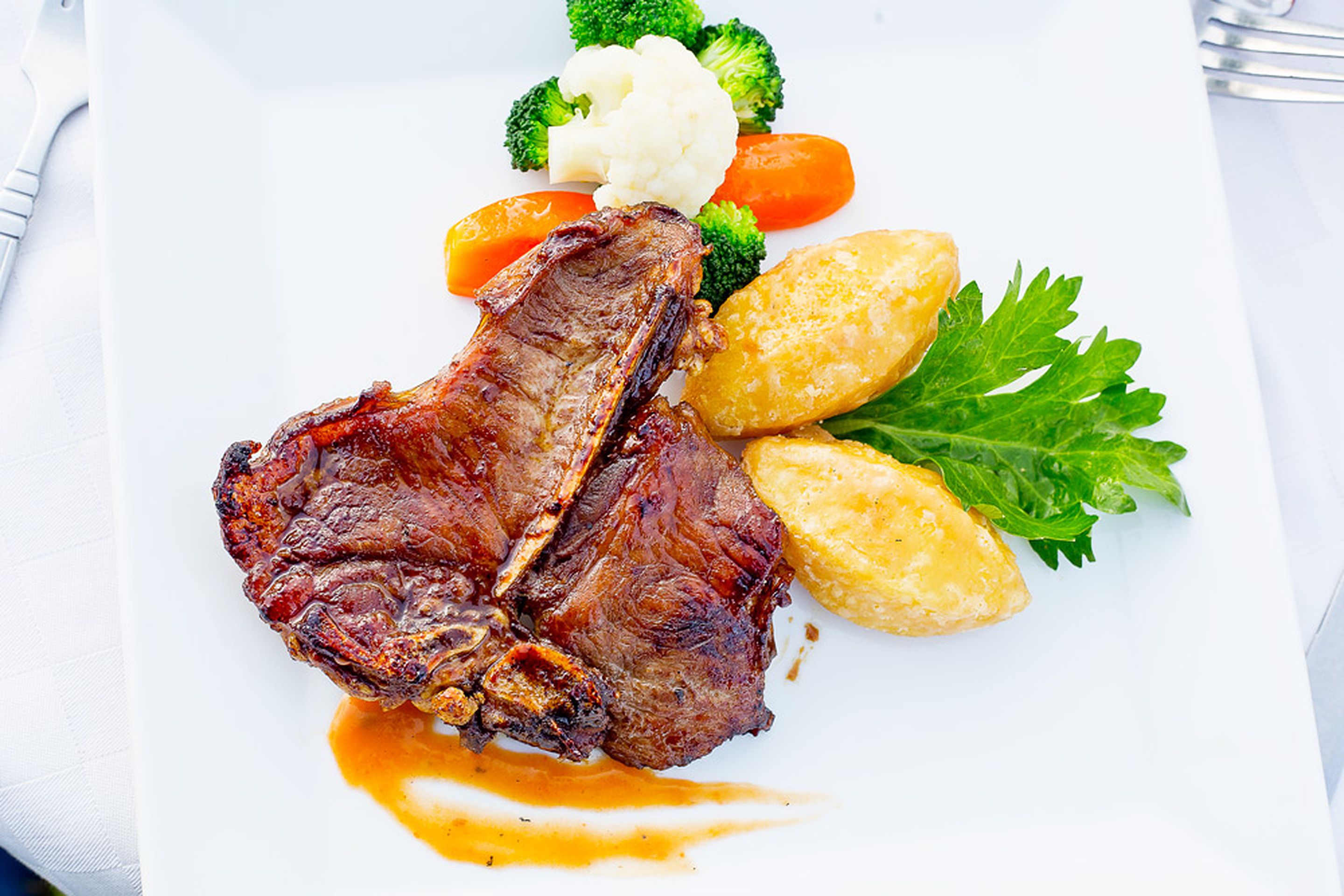 Une assiette contenant un steak, des brocolis, des carottes et des pommes de terre.