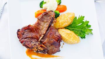 Une assiette contenant un steak, des brocolis, des carottes et des pommes de terre.