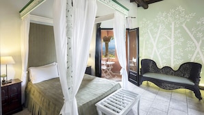 Un dormitorio con cama con dosel, un banco y vistas al exterior.