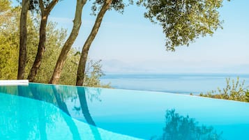 Outdoor pool, an infinity pool, pool umbrellas, sun loungers