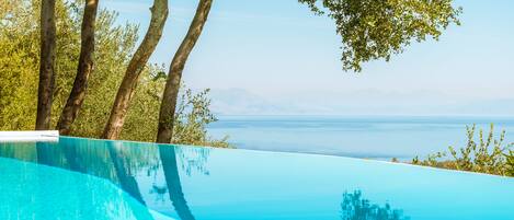 Outdoor pool, an infinity pool, pool umbrellas, sun loungers