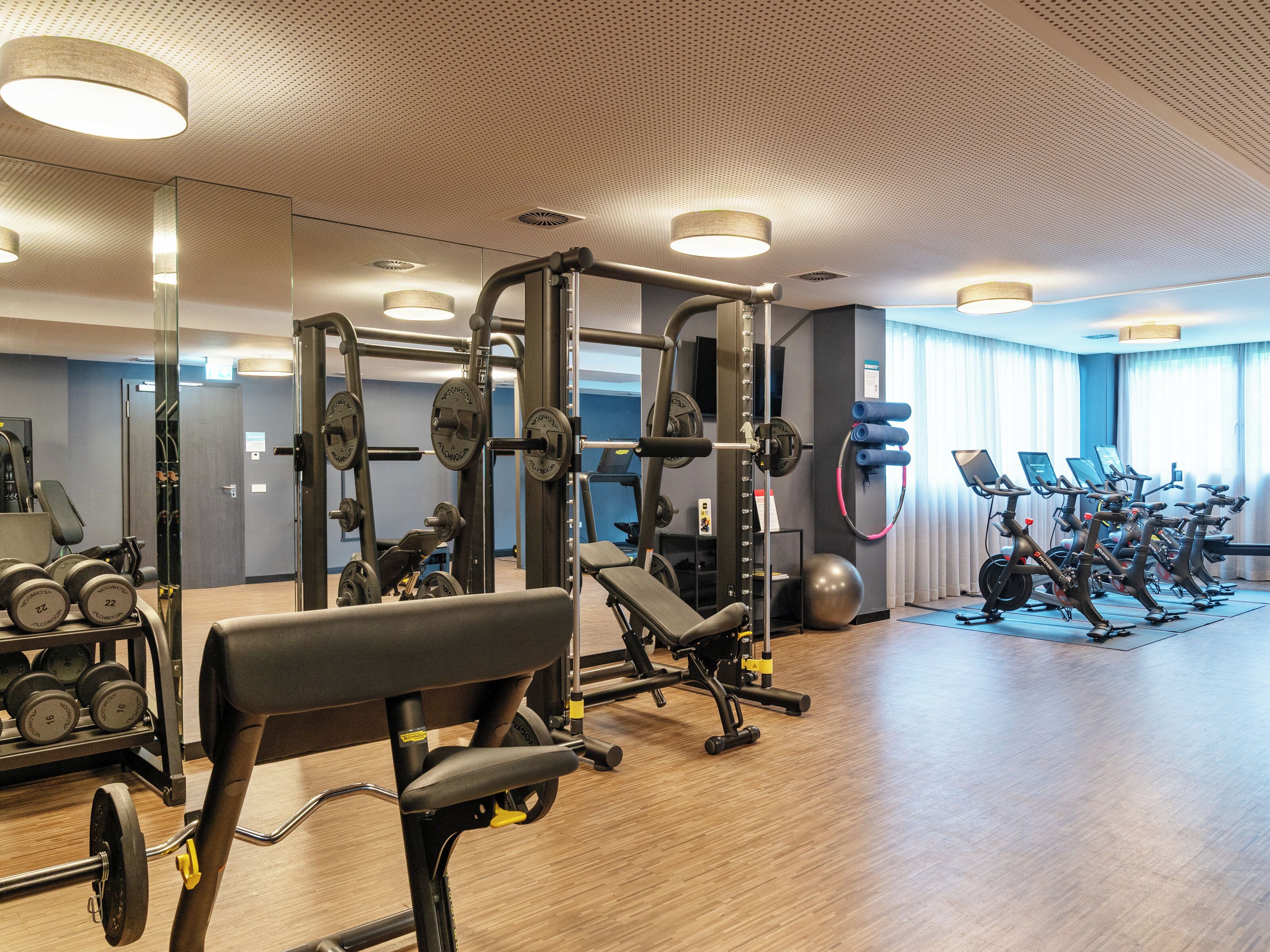 Une salle de sport équipée de divers appareils d’entraînement, notamment des appareils de musculation, des haltères et des appareils de cardio.