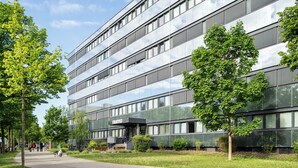 Un bâtiment moderne à plusieurs étages, doté de grandes fenêtres et d’une façade en verre.