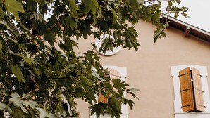 A building with multiple windows, a central entrance, and potted plants in front. - Logis Hôtel du Parc (Cransac)
