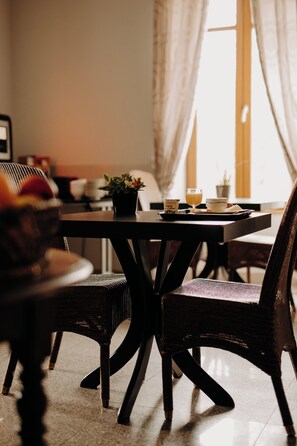 A dining table with chairs, a potted plant, and a fruit bowl. - Logis Hôtel du Parc (Cransac)