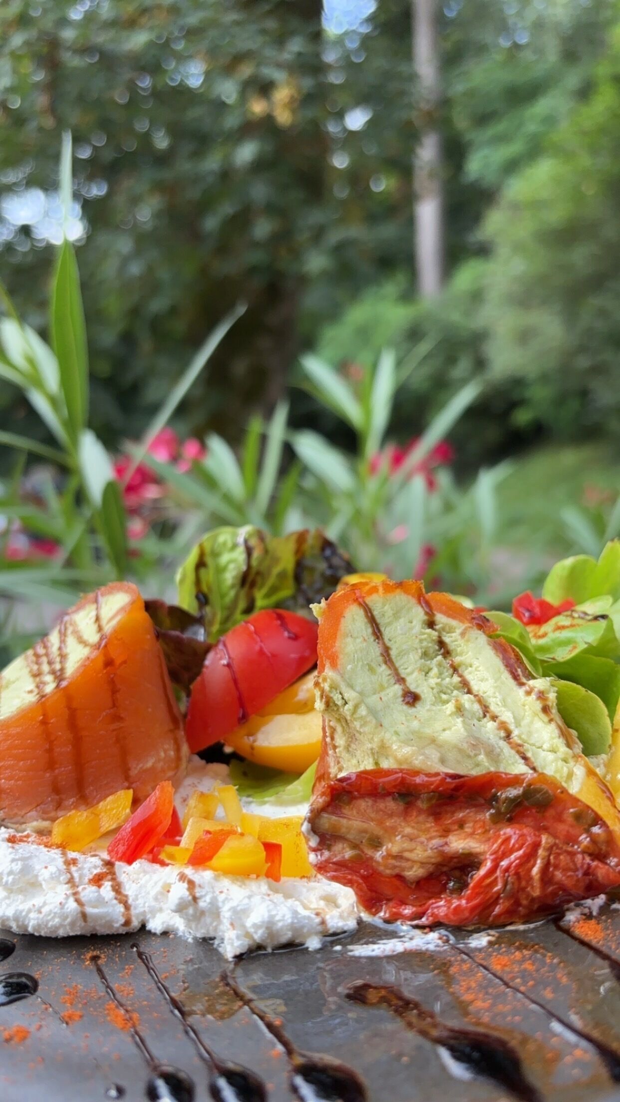A meal with various food items and a natural outdoor background.