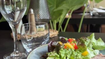 Une table à manger avec une assiette de nourriture, un verre d’eau et une fourchette.