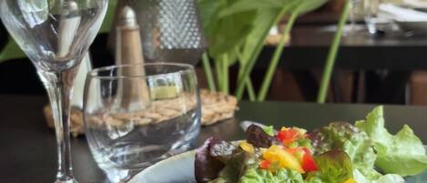 A dining table with a plate of food, a glass of water, and a fork.