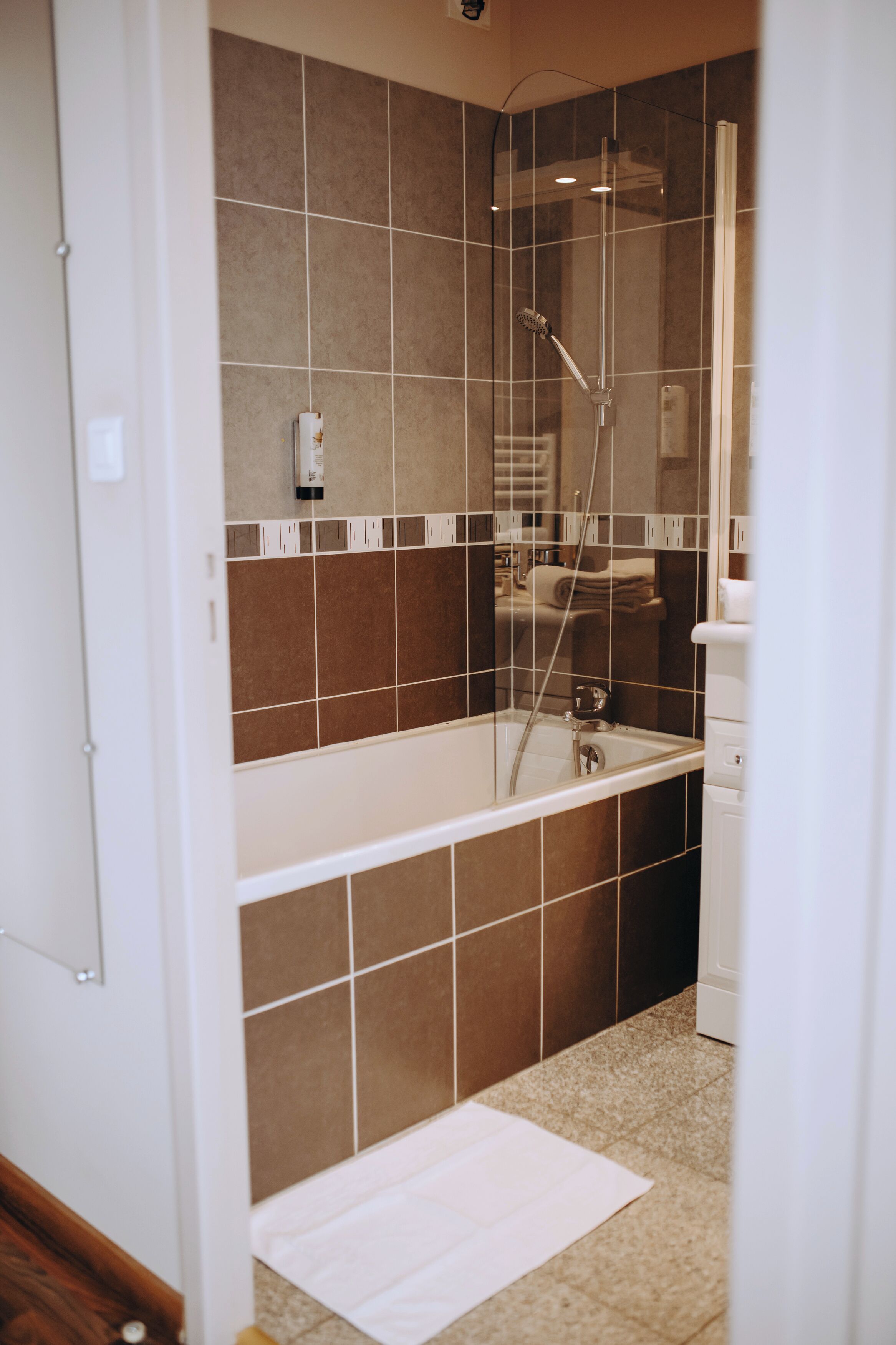 A modern bathroom with a glass-enclosed shower, a standalone bathtub, and a toilet.