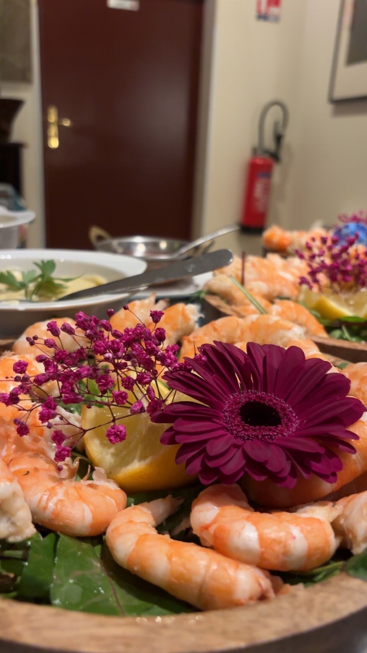 Ett fat med skaldjur, inklusive räkor, och dekorerat med blommor.