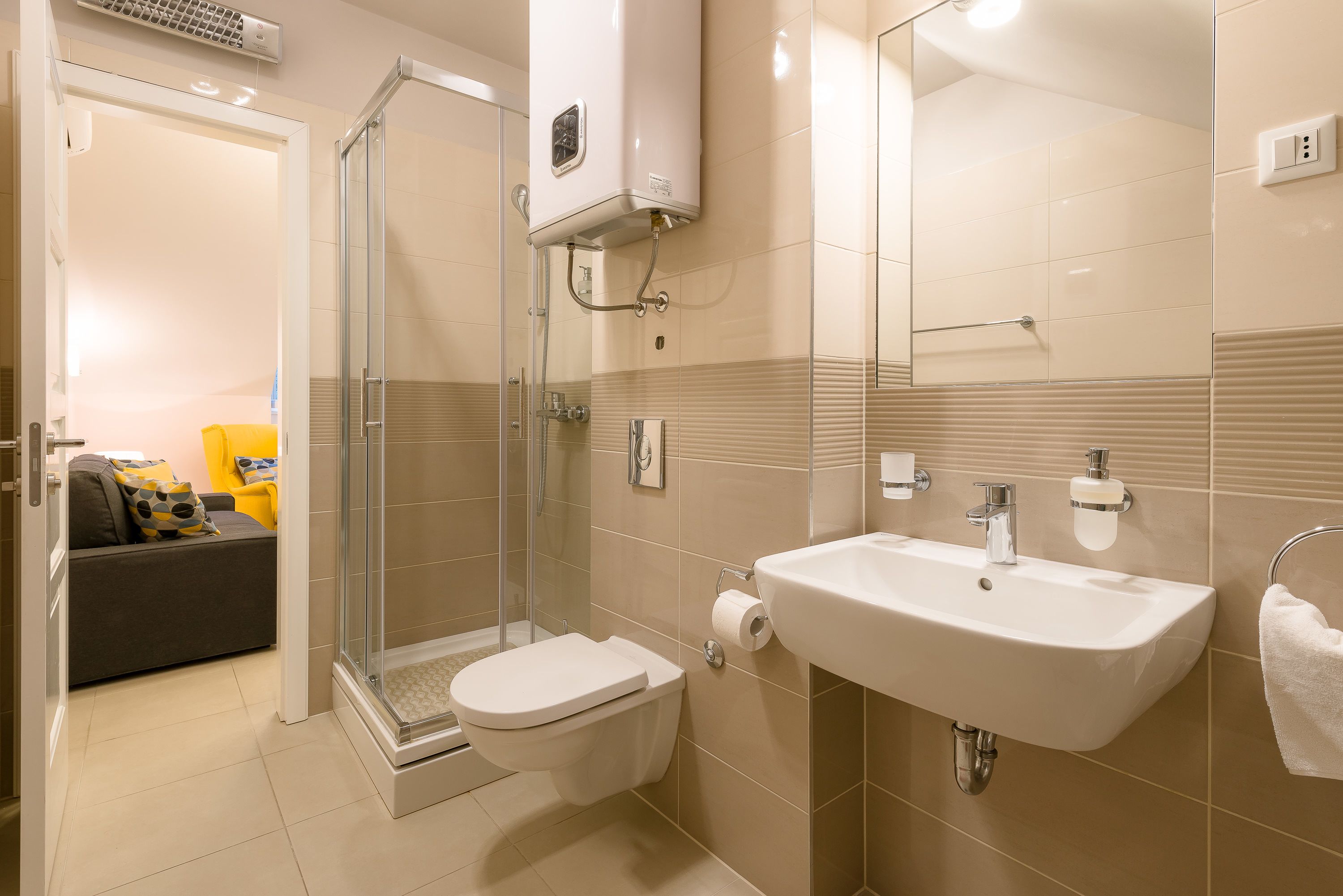Un baño con ducha, inodoro, lavabo y cabina de ducha con mampara de vidrio.