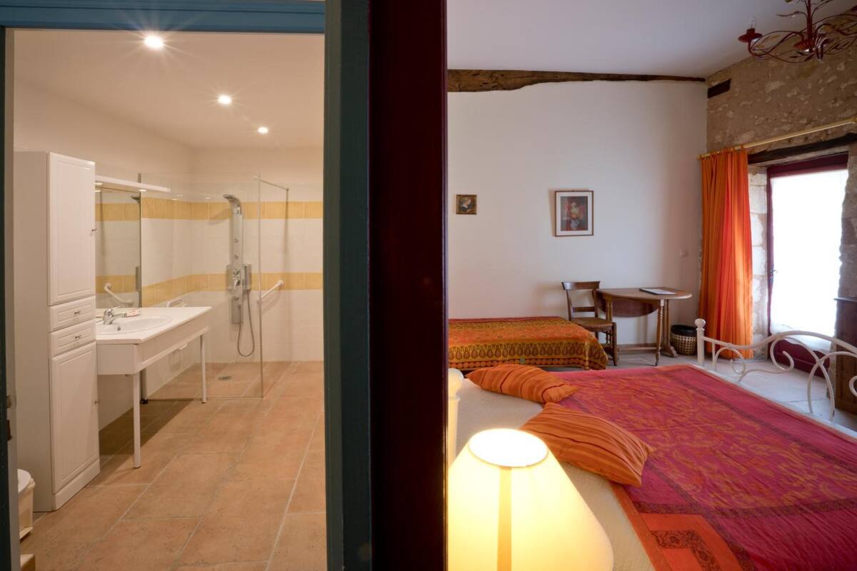 A bedroom with a bed, a desk, and a chair.