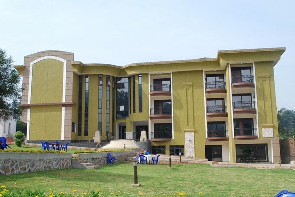 A multi-story building with a yellow facade, large windows, and balconies.