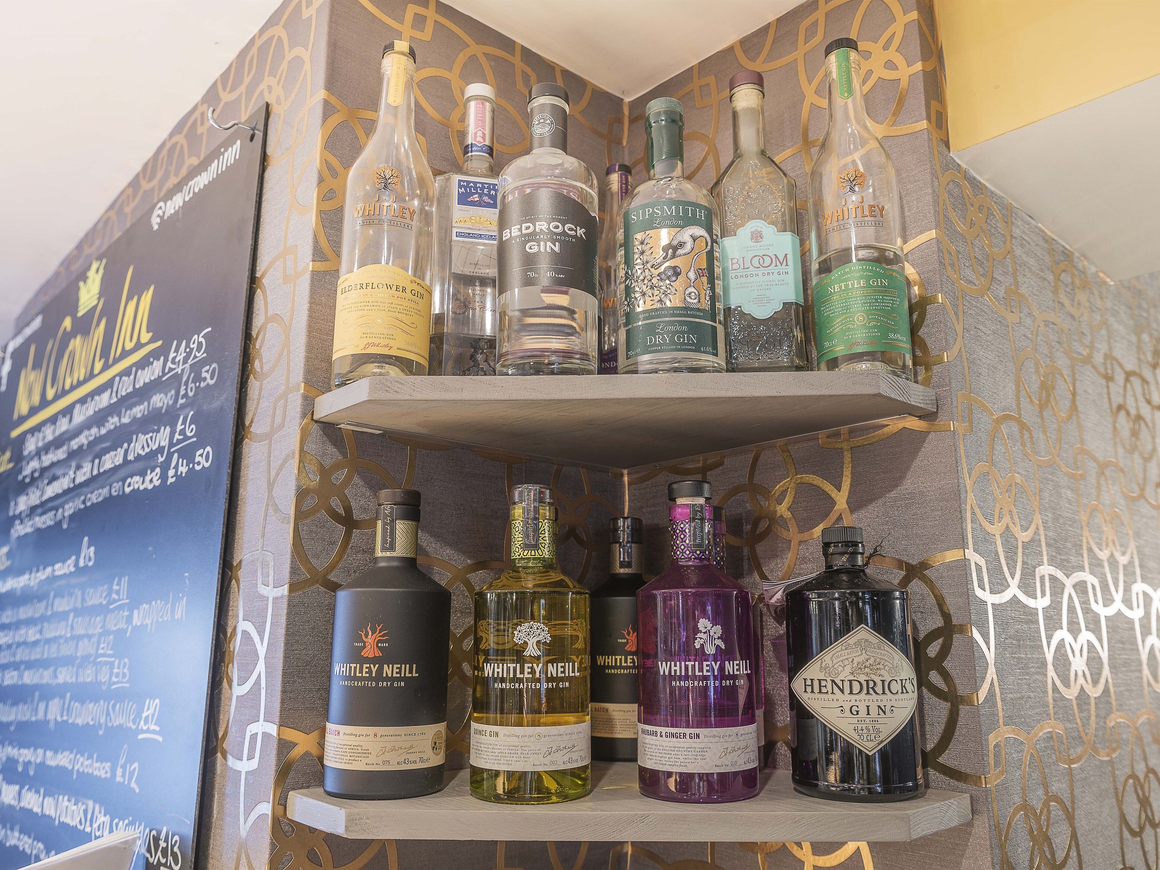 A shelf with various gin bottles.