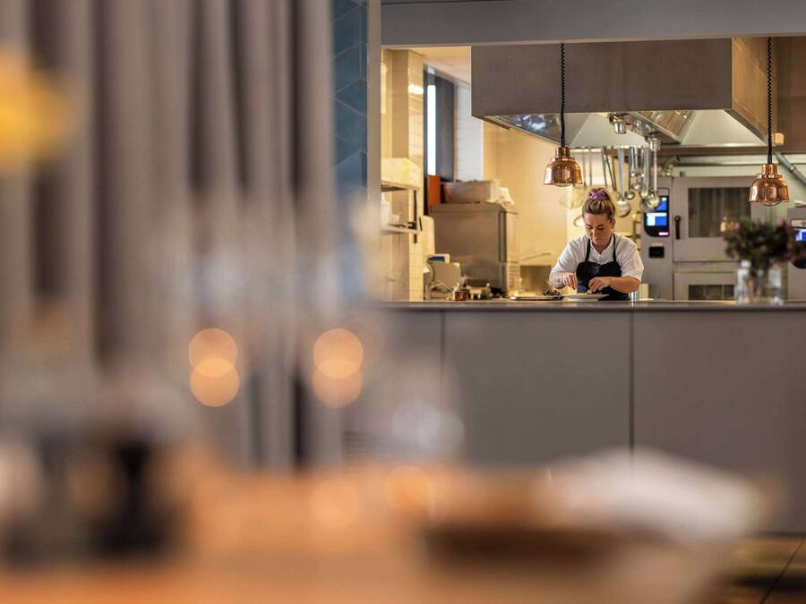 A modern kitchen with stainless steel appliances and pendant lighting.