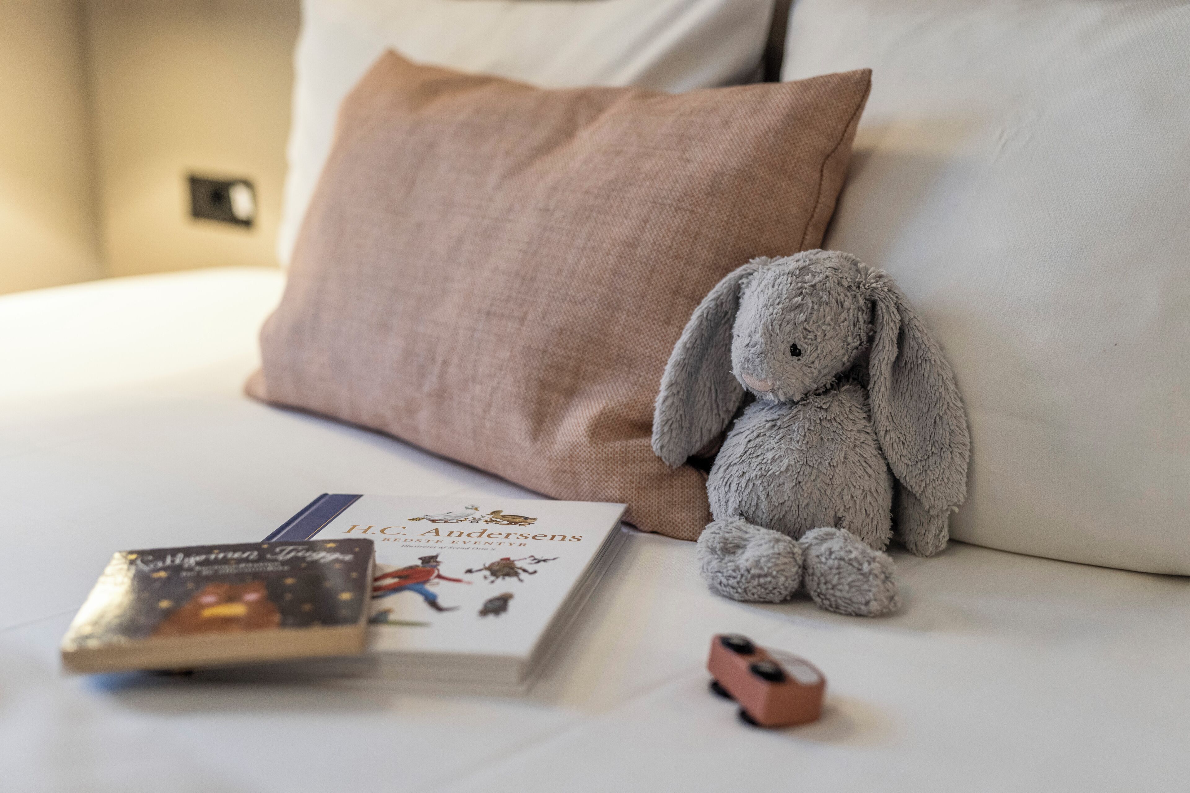 A bed with a pillow, a book, and a stuffed toy.