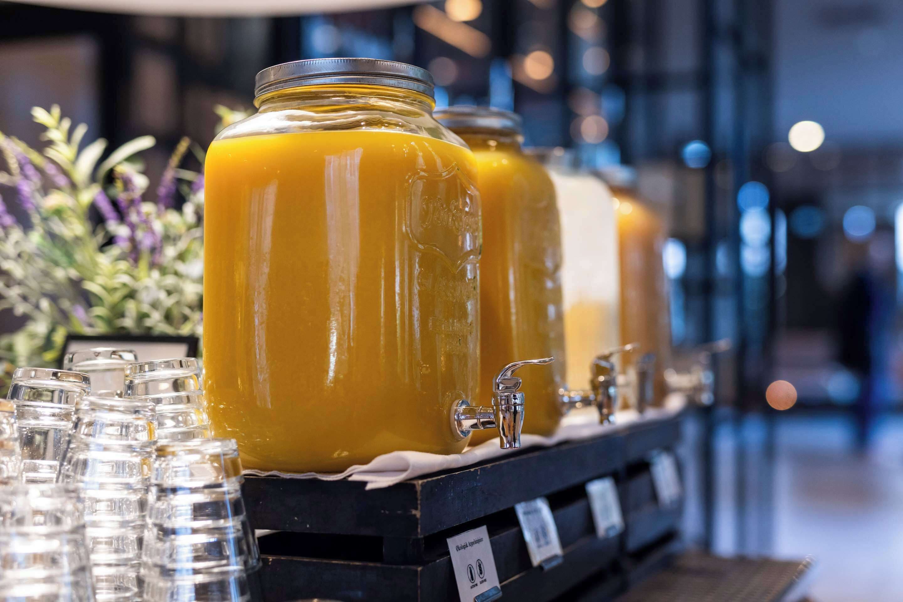A juice bar with large dispensers and glasses.