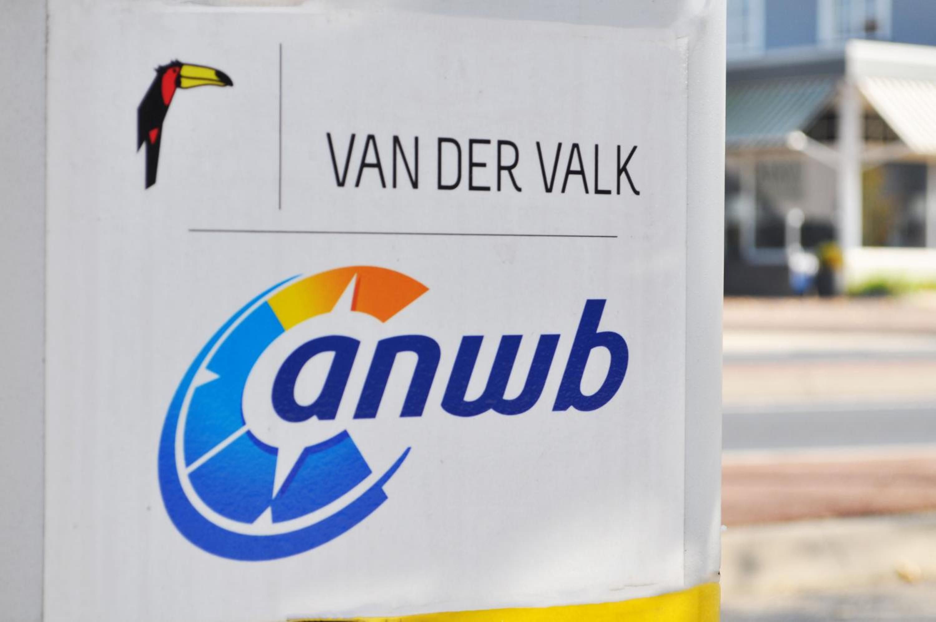 A sign with the text 'VAN DER VALK' and a logo with a recycling symbol.