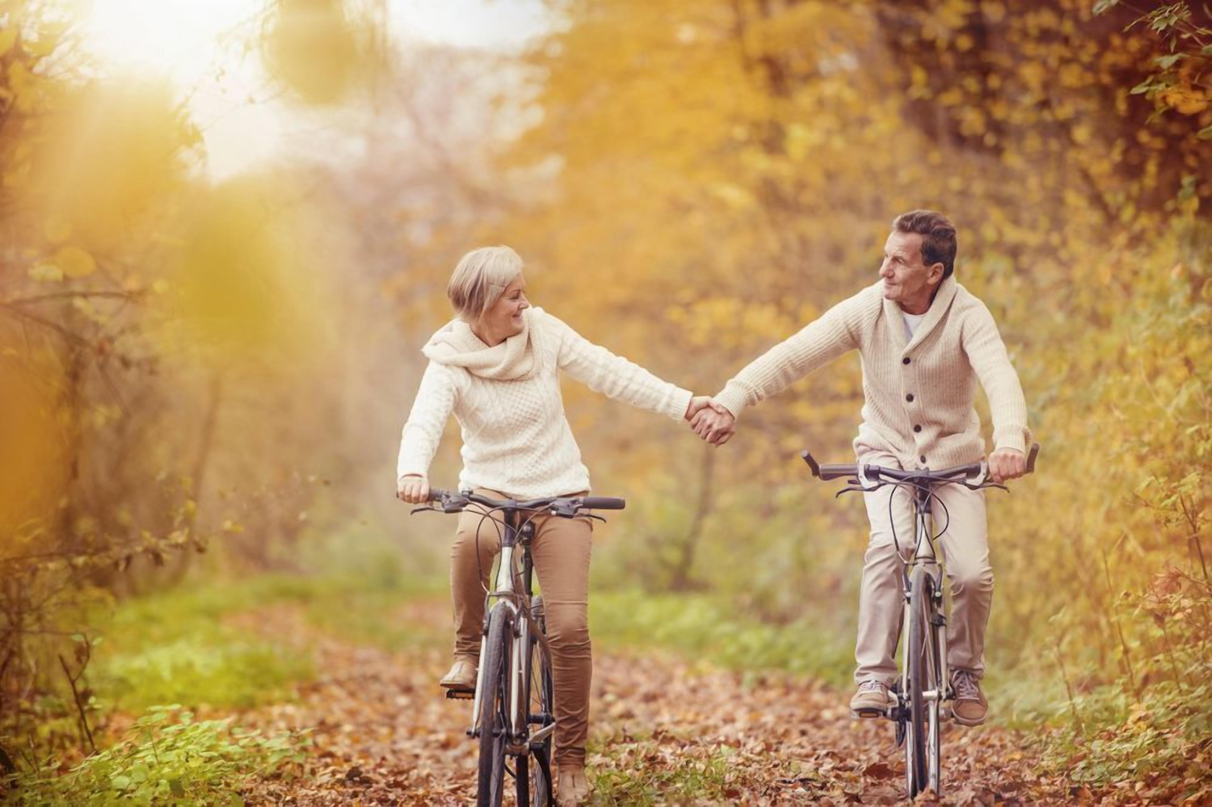 Dos personas en bicicleta en un área boscosa.