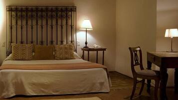 Ein Hotelzimmer mit Bett, Schreibtisch, Stuhl und Lampe.